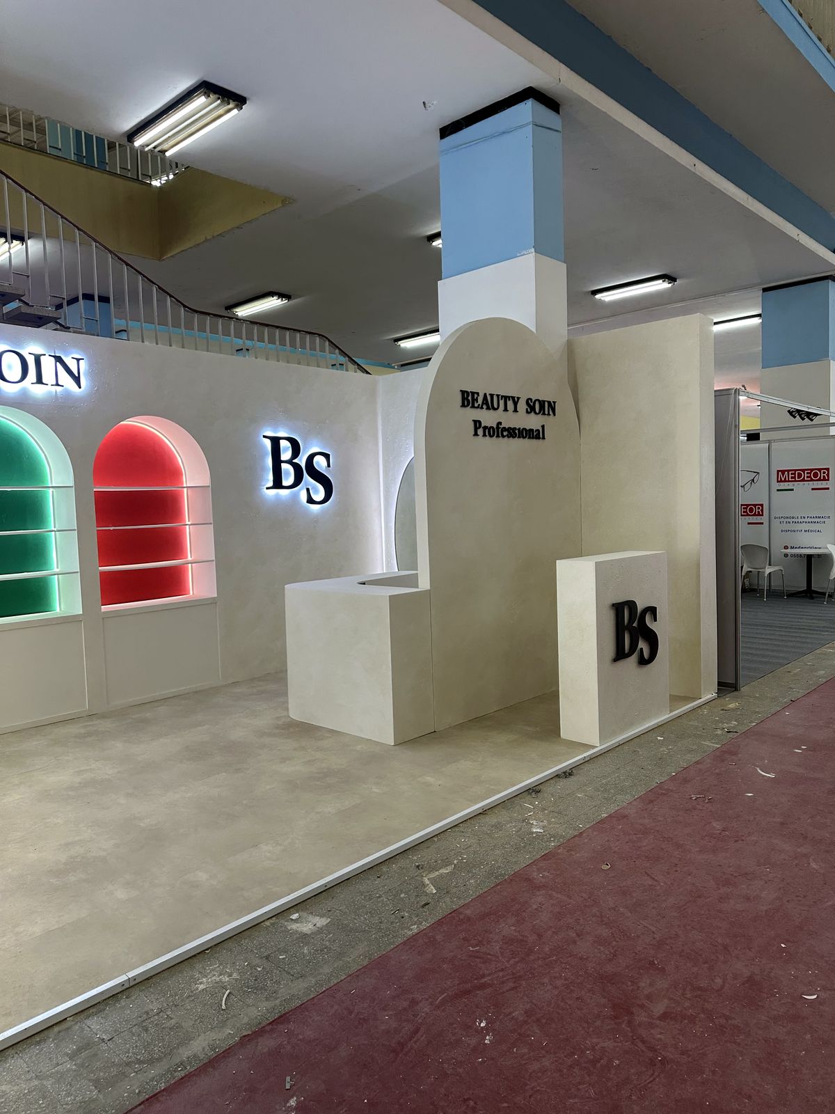Stand Beauty Soin avec arches rétroéclairées colorées et logo lumineux